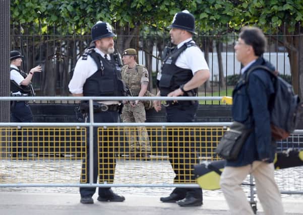 A soldier joins police outside the Palace of Westminster, London. PIC: PA