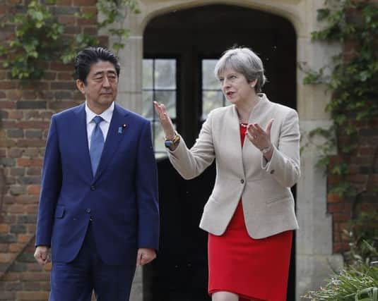 Prime Minister Theresa May shows Japan's Prime Minister Shinzo Abe around the gardens at her country residence Chequers as she welcomes him for talks. Photo:  Kirsty Wigglesworth/PA Wire