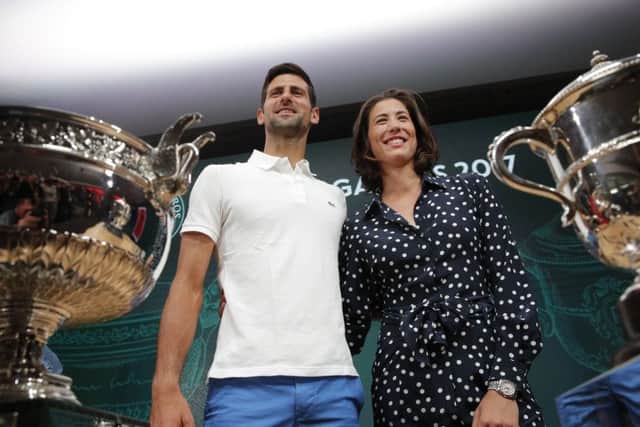 Defending champions Serbia's Novak Djokovic and Spain's Garbine Muguruza pose in front of the cups during the draw for the French Open tennis tournament at Roland Garros in Paris. Picture: AP/Christophe Ena