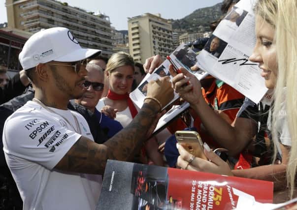 Mercedes driver Lewis Hamilton of Britain signs autographs in Monaco. Picture: AP/Claude Paris