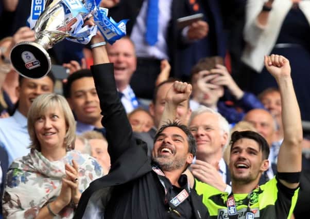 Chris Schindler, whose penalty won the shoot-out against Reading, watches as Huddersfield Towns head coach David Wagner raises the Championship play-off trophy (Picture: Mike Egerton/PA).