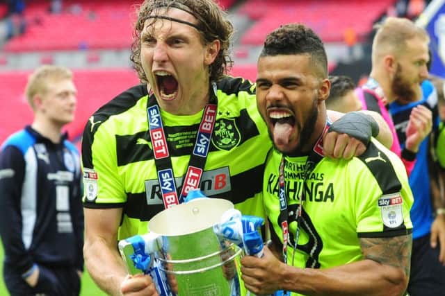 Huddersfield Town's Michael Hefele and Elias Kachunga enjoy the lap of honour as they show off the trophy to their travelling support (Picture: Simon Hulme).