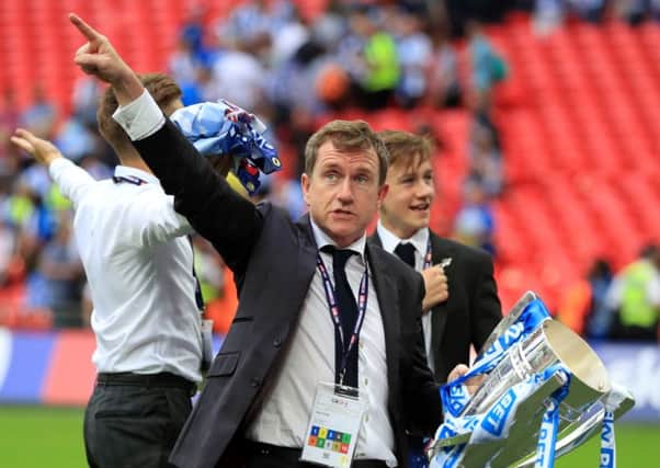 Huddersfield Town owner Dean Hoyle points to the stands as he clutches the Championship play-off final trophy after the Terriers penalty shoot-out win over Reading at Wembley (Picture: Mike Egerton/PA).