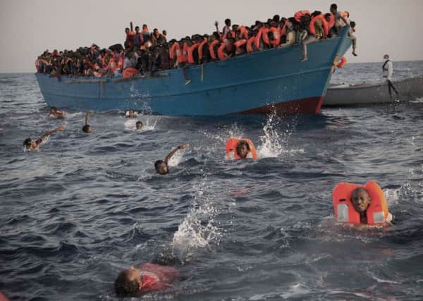 Migrants, most of them from Eritrea, jump into the water from a crowded wooden boat as they are helped by members of an NGO during a rescue operation at the Mediterranean sea, about 13 miles north of Sabratha, Libya, Monday, Aug. 29, 2016. Thousands of migrants and refugees were rescued Monday morning from more than 20 boats by members of Proactiva Open Arms NGO before transferring them to the Italian cost guards and others NGO vessels operating at the zone.(AP Photo/Emilio Morenatti)
