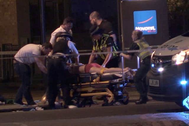 Screengrab taken from PA Video footage of people receiving medical attention in Thrale Street near London Bridge following a terrorist incident.