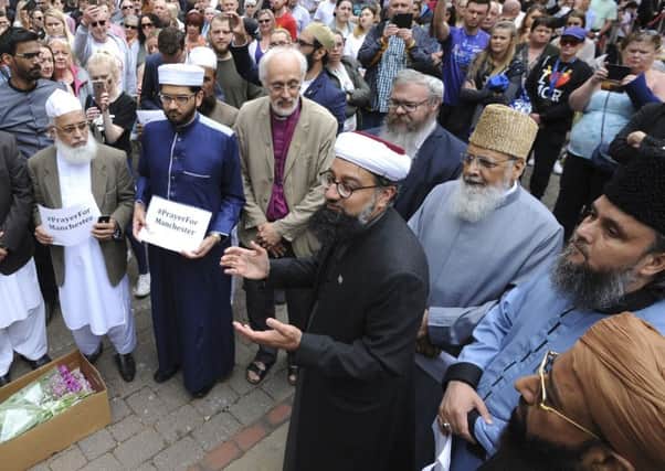 Members of the British Muslim Forum and religious leaders from Christian and Jewish faiths pay their respects at St Ann's square in Manchester, following last month's bombing. (AP).