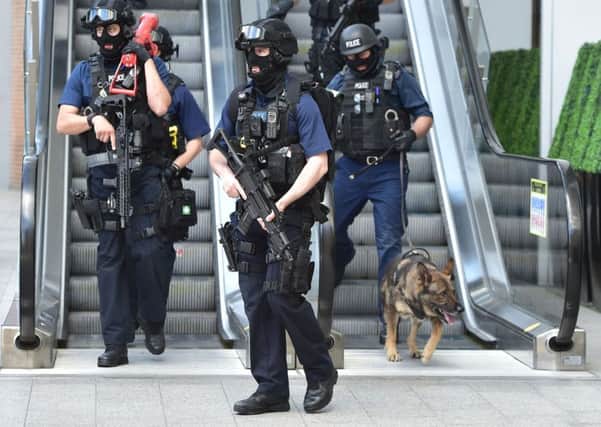 Armed police descend an escalator at the foot of the Shard outside London Bridge station, near the scene of Saturday night's terrorist incident.  (PA).