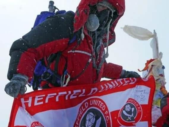 Owls fan Ian Toothill plants the Blades flag at the summit of Mount Everest.