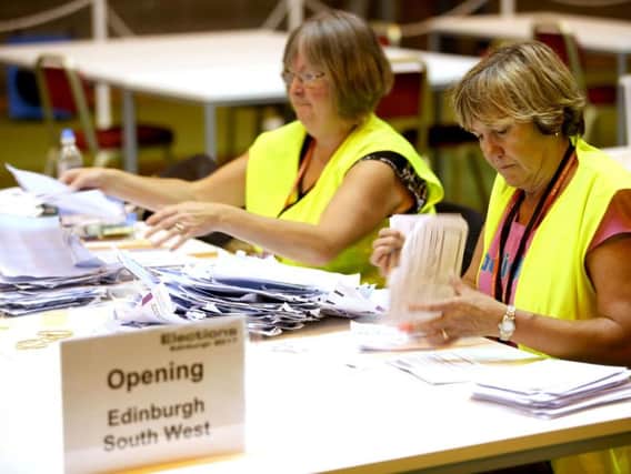 Election staff sort postal votes ahead of the General Election count at Meadowbank Sports Centre in Edinburgh. PA
