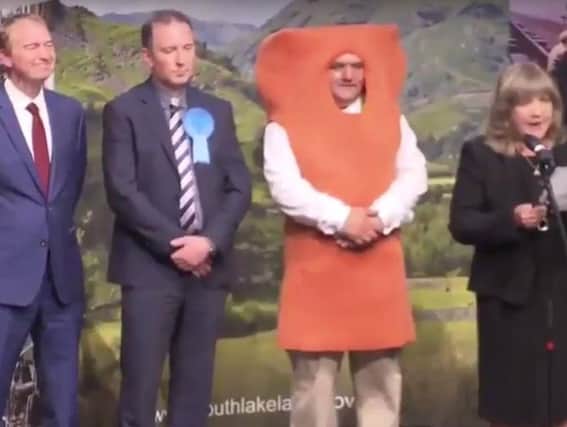 Mr Fish Finger goes head to head with Tim Farron (left).