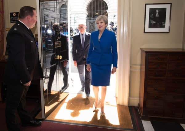 Prime Minister Theresa May and her husband Philip walk into 10 Downing Street after seeing  Queen Elizabeth II where she asked to form a new government.