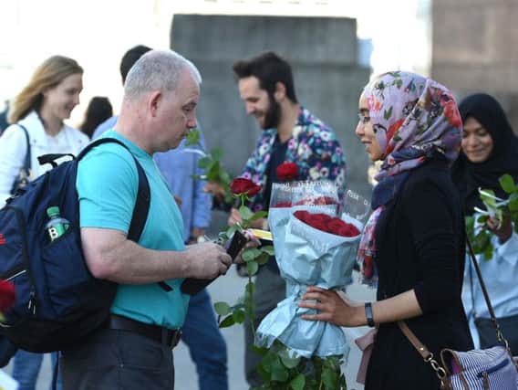 Roses with messages are given out to passers-by on London Bridge just over a week on from the terror attack on the bridge and at Borough Market. PA