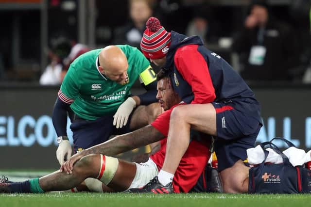 Courtney Lawes receives treatment for a head injury before being substituted
