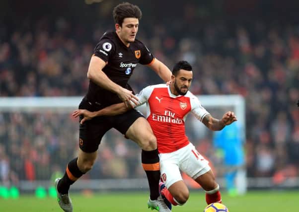 Hull City's Harry Maguire (left) battles Arsenal's Theo Walcott in the Premier League last season (Picture: PA)
