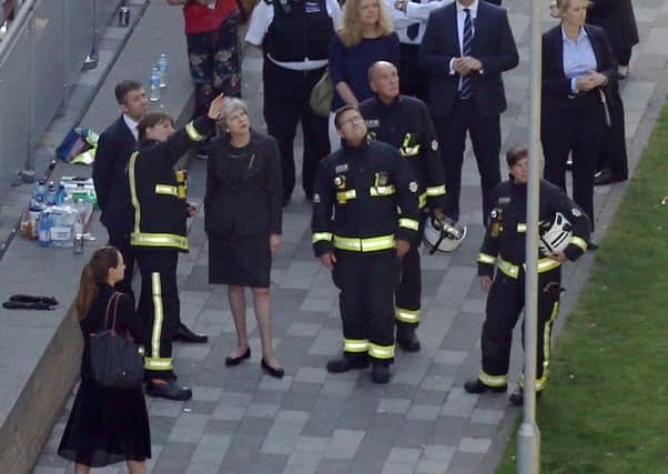 Theresa May, meeting emergency workers at the scene of the Grenfell Tower inferno.