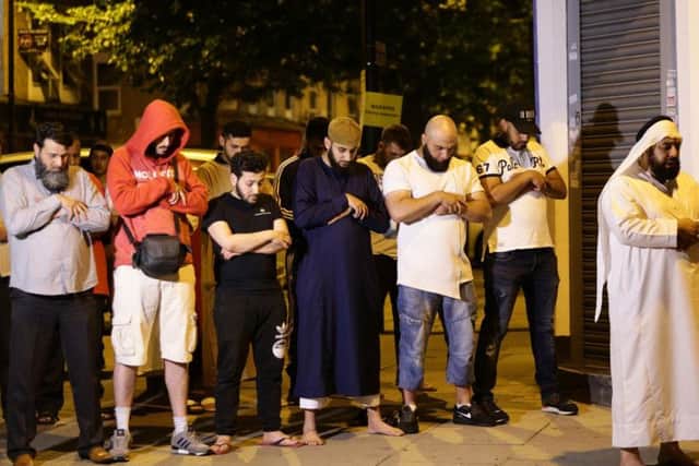 Local people observe prayers at Finsbury Park in north London.