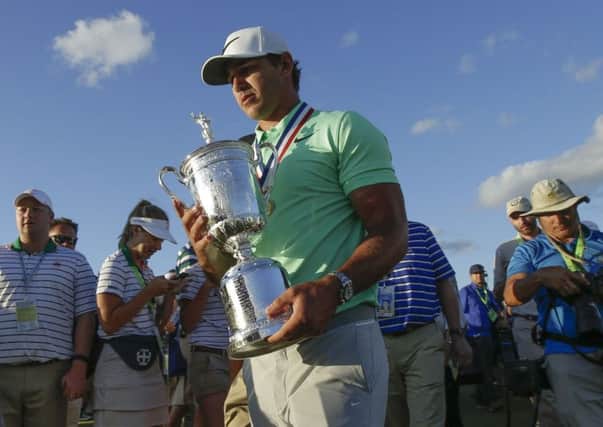 Brooks Koepka carries the winning trophy after the U.S. Open golf tournament Sunday, June 18, 2017, at Erin Hills in Erin, Wis. (AP Photo/Charlie Riedel)