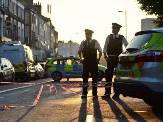 Police officers man a cordon in Finsbury Park, north London, where one man has died, eight people taken to hospital and a person arrested after a van struck pedestrians. PA