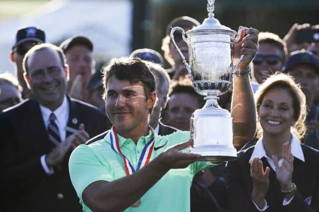 Brooks Koepka holds up the winning trophy after the U.S. Open golf tournament Sunday, June 18, 2017, at Erin Hills in Erin, Wis. (AP Photo/Chris Carlson)