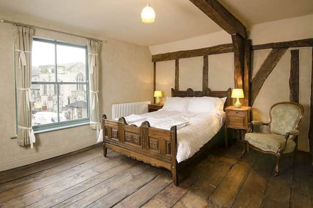 One of the apartment bedrooms with antique bed and chair from The French House. Stephen uncovered the timbers, which date from the early 1500s