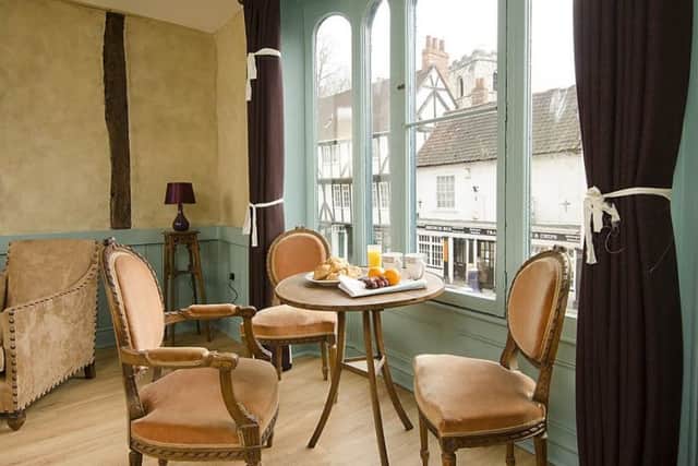 One of the holiday apartments with historic beams and cafe table with plush chairs.
