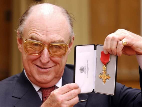 Cricket commentator Henry Blofeld proudly holds his OBE back in 2003. Blofeld will retire from his role as commentator on the BBC Radio 4's Test Match Special programme in September.