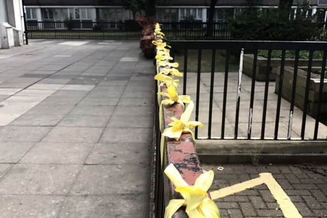 Yellow ribbons tied to railings near to the Grenfell Tower fire in west London. PIC: PA