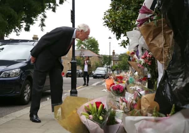 Retired Court of Appeal judge Sir Martin Moore-Bick, who will lead the Grenfell Tower fire public inquiry, looks at flowers after leaving St Clement's Church near to the tower block in London.  However concerns persist that victims don't have sufficient legal representation.
