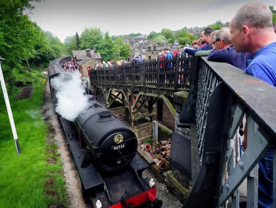 Crowds watch a steam train pass Haworth Railway Station. Picture: Simon Hulme