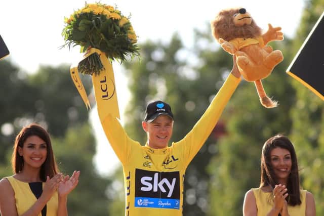 Team Sky's Chris Froome celebrates as he collects the yellow jersey for winning the 2016 Tour De France
