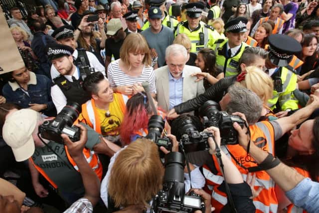 Labour leader Jeremy Corbyn is mobbed at an anti-austerity rally in London.