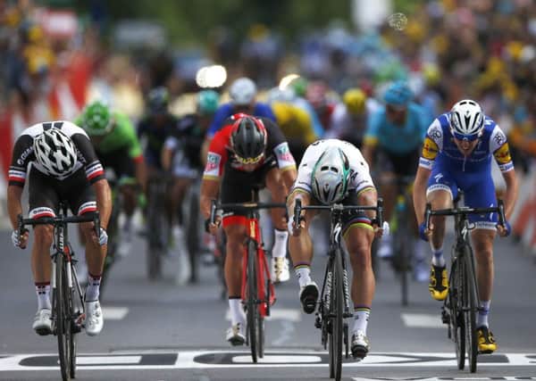 Peter Sagan of Slovakia, second right, pushes his bicycle over the finish line ahead of second place Australia's Michael Matthews, left, third place Ireland's Daniel Martin, right, and Belgium's Greg van Avermaet, second left, to win the third stage of the Tour de France.