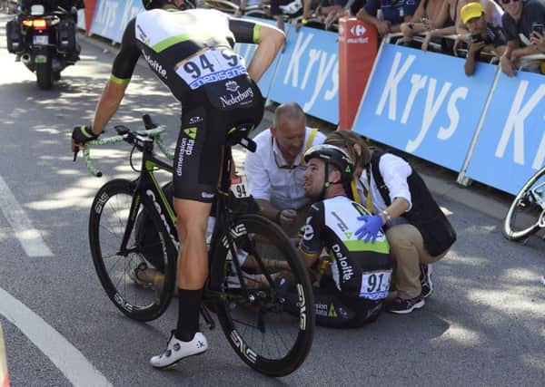Out: Britain's Mark Cavendish is treated by medics after he crashed during the sprint of the fourth stage of the Tour de France