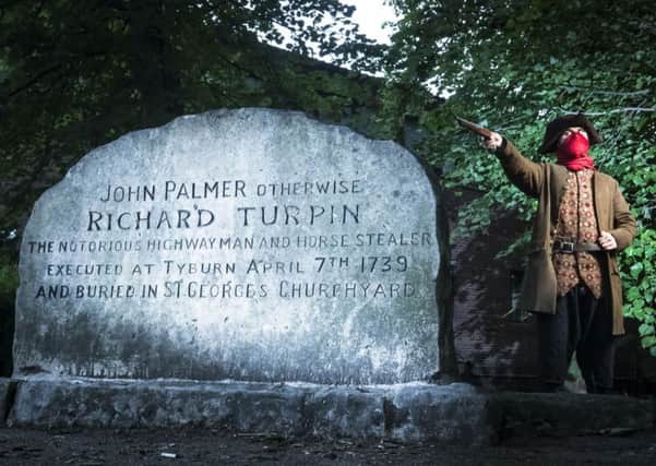 Simon Alnaimi, dressed as Dick Turpin, next to what was, until new evidence cast doubt on the claim, believed to be the grave of the 18th century highwayman, in York