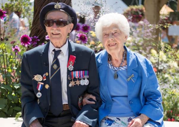 Blind D-Day veteran Alfred Barlow, 96, who lost his medals at a motorway service station, with his wife Masie, with replacements that were presented to him at a ceremony at the Hampton Court Flower Show in south west London. Steve Parsons/PA Wire