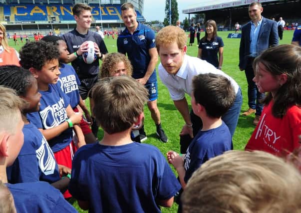 Leeds Rhinos' captain Danny McGuire, watches on as Prince Harry talks to kids during his visit to Headingley earlier this week. Picture: Simon Hulme