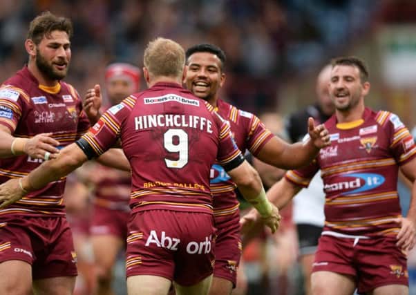 Martyn Ridyard, far right, helps Ryan Hinchcliffe celebrate scoring Huddersfield Giants' third try against Widnes Vikings.  Picture: Bruce Rollinson