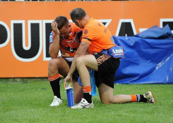 Castleford's Greg Eden is treated for a shoulder injury after scoring his second try of the night against Salford. Picture: Matthew Merrick.