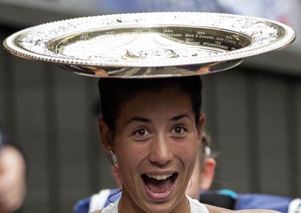 Garbine Muguruza balances the trophy on her head as she walks off court after beating Venus Williams in the Ladie's Singles final (Picture: Steven Paston/PA Wire)