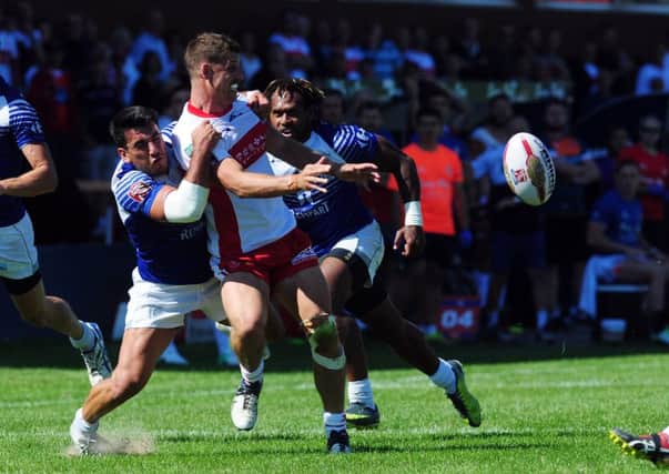 Hull KR player Jake Butler-Fleming releases the ball uinder pressure from the Toulouse defence.