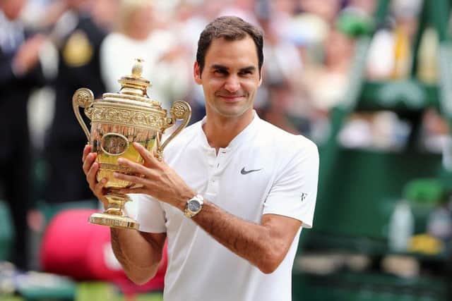 TOGETHER AGAIN: Roger Federer with the Wimbledon men's singles trophy he has now won a record-breaking EIGHT times. Picture: Gareth Fuller/PA.
