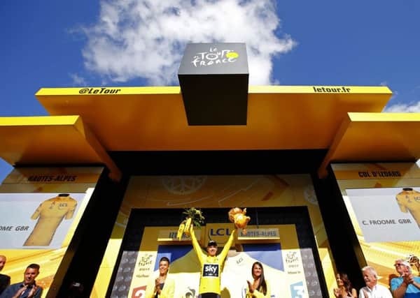 Chris Froome, wearing the overall leader's yellow jersey, celebrates on the podium after the 18th stage of the Tour de France. Picture: AP/Peter Dejong.