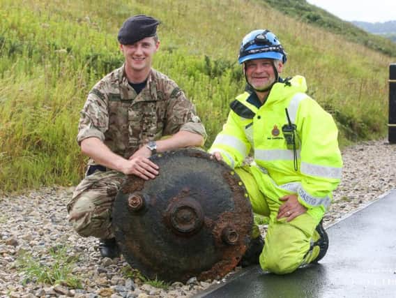 The landmine being posed with by the bomb squad and HM Coastguard. Photo: Ceri Oakes Photography