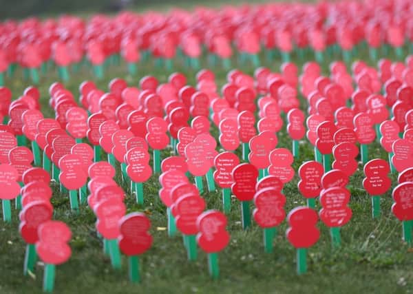 Poppies with messages written on them on display next to Tyne Cot Commonwealth War Graves Cemetery, near to Ypres in Belgium . PIC: PA