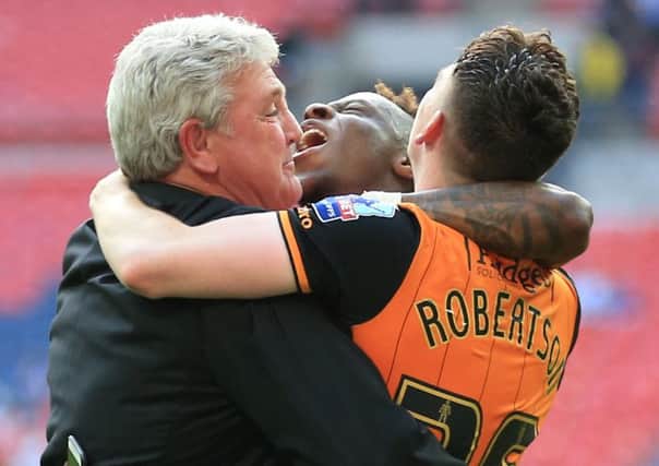 Happy days: Hull City manager Steve Bruce celebrates with Moses Odubajo and Andrew Robertson after winning the Championship play-off final at Wembley