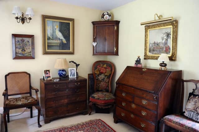 A corner of the sitting room with  a chair that is part of Susan's collection of furniture and furnishings featuring needlework