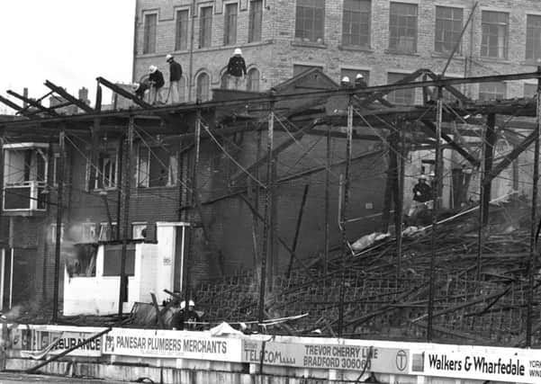 File photo dated 11/05/1985 of smoke still rising from the charred remains of the main stand at the Valley Parade football ground after the blaze was brought under control, as hundreds of people are expected to gather today to mark the 30th anniversary of the deaths of 56 footballs fans in the Bradford City fire. PRESS ASSOCIATION Photo. Issue date: Monday May 11, 2015. Current and former players will be joined by fans and civic dignitaries in Bradford's Centenary Square for a minute's silence and a service to remember the horrific events of May 11, 1985. Photo credit should read: PA Wire
