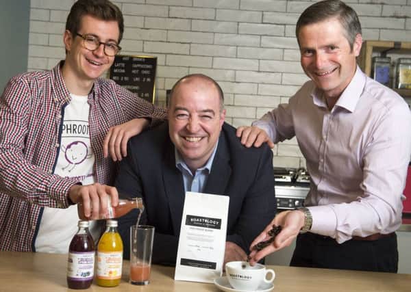 Jerome Jacob, of Phrooti, and Bryan Unkles of Cafeology serve up drinks to general manager of the Jonas Hotel Andy Flowers as they strike up deals to supply the newly opened hotel