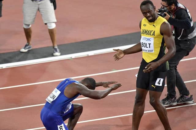 United States' Justin Gatlin, left, bows as he celebrates his win in the Men's 100 meters final as third placed Jamaica's Usain Bolt watches during the World Athletics Championships in London. (AP Photo/Martin Meissner)