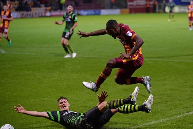 Bradford Citys Dominic Poleon leaps over an attempted tackle from Doncaster Rovers prostrate Joe Wright (Picture: Bruce Rollinson).